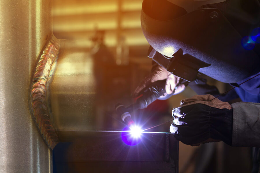 Welder is welding the steel in the factory.