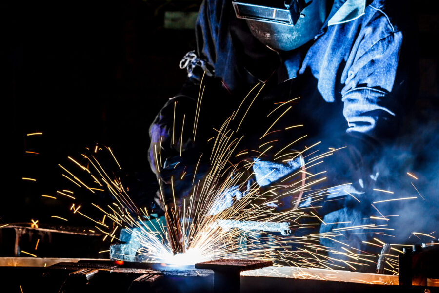 worker with protective mask welding metal